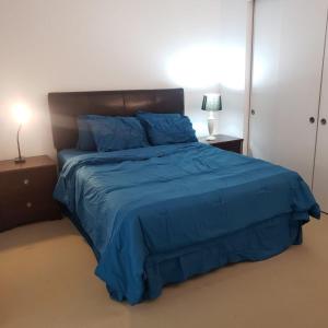 a bedroom with a bed with a blue comforter at Lovely Guest Entire Apartment in Ottawa