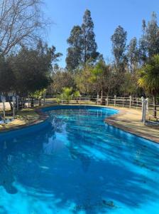 - une piscine d'eau bleue dans un parc dans l'établissement Cabañas el Yacal, à El Bolsico