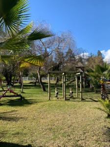 a playground in a park with a swing set at Cabañas el Yacal in El Bolsico