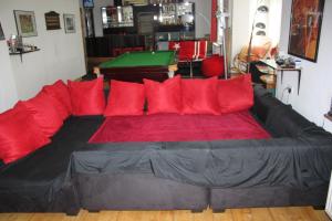 un divano nero con cuscini rossi in soggiorno di Privatzimmer Hagen a Hagen