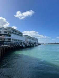 une rivière avec des bâtiments et un bateau dans l'eau dans l'établissement Waterfront Seaview Hotel Apartment - same building block as Auckland Hilton, à Auckland