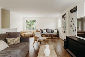 a living room with a couch and chairs and a tv at The Beach House, 25 Tomaree Road - fantastic house with pool, linen in Shoal Bay