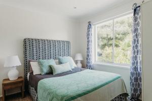 a bedroom with a bed and a window at The Beach House, 25 Tomaree Road - fantastic house with pool, linen in Shoal Bay