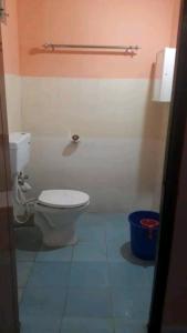 a bathroom with a toilet and a blue bucket at Pandeys Homestay Kalimpong in Kalimpong