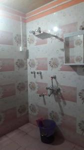 a bathroom with a shower with flowers on the wall at Pandeys Homestay Kalimpong in Kalimpong