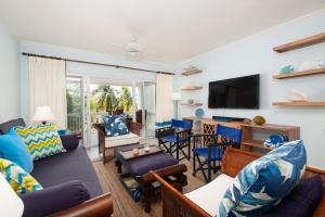 a living room filled with furniture and a flat screen tv at Jamaica Time Driftwood at Sea Palms 3BR 3BA Condo in Ocho Rios with Pool and Beach Front with Views ONLY 10 Mins from Ochi Intl Airport Direct flight from Miami in St Mary