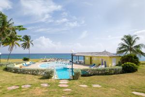 a resort with a swimming pool and the ocean at Jamaica Time Driftwood at Sea Palms 3BR 3BA Condo in Ocho Rios with Pool and Beach Front with Views ONLY 10 Mins from Ochi Intl Airport Direct flight from Miami in St Mary