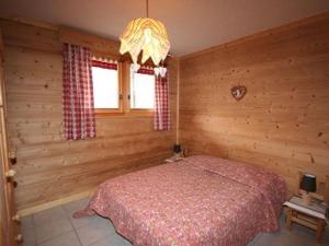 a bedroom with a bed and a chandelier at Chalet cosy 3* avec terrasse, 3 pièces pour 6 pers., proche centre et remontées mécaniques - Châtel - FR-1-676-63 in Châtel