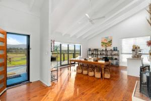 a living room with a table and a large window at The Lane Retreat in Pokolbin
