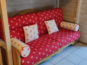 un sofá rojo en una habitación con almohadas en Studio Châtel, 1 pièce, 4 personnes - FR-1-676-98, en Châtel
