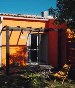 uma casa com um alpendre e uma cadeira em frente em Aparts Dunas de Valizas em Barra de Valizas