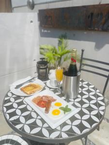 - une table avec une assiette d'œufs et une bouteille de vin dans l'établissement The Cubes, à Lusaka