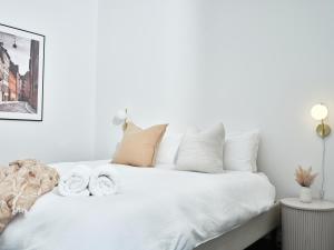 a white bedroom with a bed with towels on it at Chic Urban Loft in Prime Location in Melbourne