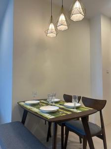 a dining room table with plates and glasses on it at Cozy*Home@Riverine Diamond 2 in Kuching