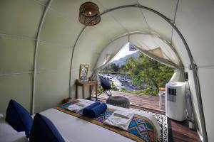 a bed in a dome tent with a view of a river at Natya River Sidemen in Silebeng