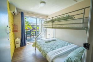 a bedroom with two bunk beds and a balcony at The Hostel, Airlie Beach in Airlie Beach