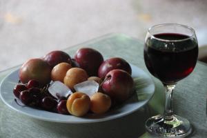a plate of fruit next to a glass of wine at Plaj Hotel in Cıralı +74 photos
