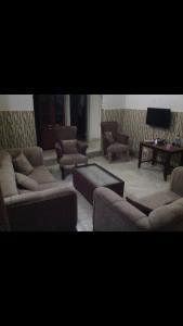 een woonkamer met banken en stoelen en een televisie bij Dab view bungalow Rental in Sere Kunda