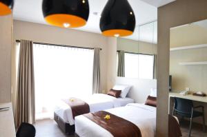 Habitación de hotel con 2 camas y espejo en Student Park Hotel, en Yogyakarta