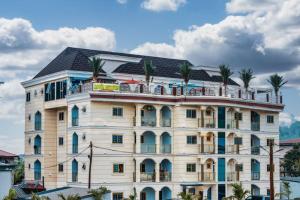 a large white building with palm trees on top of it at Rovie Estates in Buea