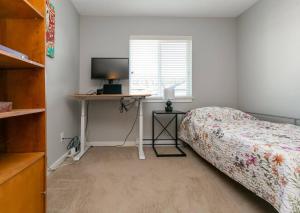 ビクトリアにあるEntire 3-bedroom house Near Townのベッドとパソコン付きの机がある寝室