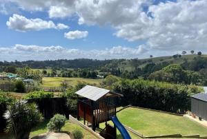 uma vista para um parque infantil com escorrega em Bluebell Cottage em Beechmont