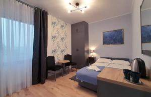 um quarto com uma cama, uma secretária e uma janela em Trzy Kolory em Polanica-Zdrój