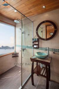 a bathroom with a shower and a sink and a mirror at Minh Hằng Cruise in Ha Long