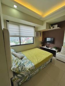 a small bedroom with a bed and a window at Horizons 101 Condo in Cebu City in Cebu City
