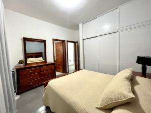 a bedroom with a bed and a mirror and a dresser at Casa privada - Centro del pueblo. in Constanza