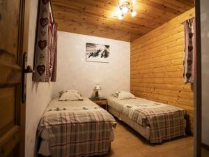 zwei Betten in einem Zimmer mit Holzwänden in der Unterkunft Chalet cosy à Châtel - 2 pièces, 4 pers, WiFi, Animaux admis, Parking - FR-1-676-166 in Châtel