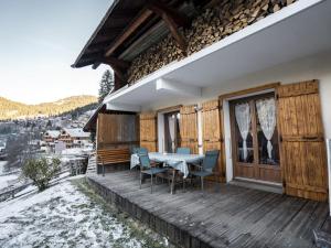 eine Holzterrasse mit einem Tisch und Stühlen auf einem Haus in der Unterkunft Chalet cosy à Châtel - 2 pièces, 4 pers, WiFi, Animaux admis, Parking - FR-1-676-166 in Châtel