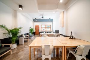 una oficina con una gran mesa de madera y sillas en Socialer Coliving & Coworking Space, en Chiang Mai