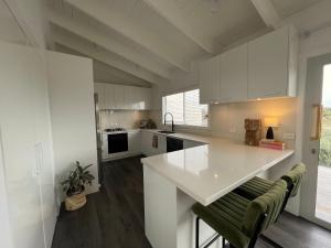a kitchen with white cabinets and a white counter top at Rye Beach House - Sunset Views in Rye