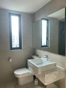 een badkamer met een wastafel, een toilet en een spiegel bij Ooak Residence in Mont Kiara, Kuala Lumpur in Kuala Lumpur