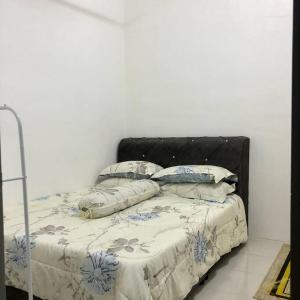 Schlafzimmer mit einem Bett mit einem schwarzen Kopfteil und Kissen in der Unterkunft Salak Cemara Homestay Klia/Klia2 in Sepang