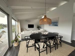 a dining room with a table and a couch at Rye Beach House - Sunset Views in Rye