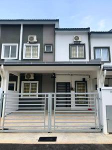 una casa con una recinzione bianca davanti di Salak Cemara Homestay Klia/Klia2 a Sepang