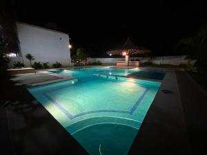 a swimming pool lit up at night at ¡Descubre tu oasis en Acapulco! Casa vacacional. in Acapulco
