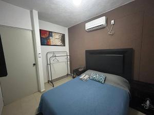 a bedroom with a blue bed and a air conditioner at ¡Descubre tu oasis en Acapulco! Casa vacacional. in Acapulco +20 photos