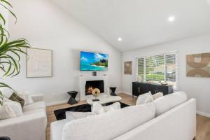 a living room with white furniture and a fireplace at Vineyard Chic Oasis: Modern Elegance near Temecula Wineries in Temecula