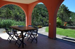 a table and chairs on a patio with arches at Rossola House in Bonassola