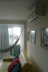 a living room with a couch and a window at Tambaú Israel Flat 417 in João Pessoa