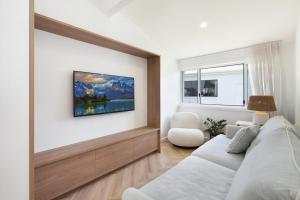 a living room with a bed and a tv on the wall at Boat Harbour Haven in Bonnells Bay