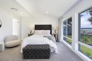 a bedroom with a bed and a large window at Boat Harbour Haven in Bonnells Bay