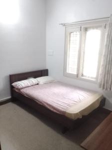 a bed sitting in a room with a window at Jamesville-4BHK Villa, Wi-Fi, SmartTV - CityCentre in Bangalore