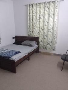 1 dormitorio con cama y ventana con cortina en Jamesville-4BHK Villa, Wi-Fi, SmartTV - CityCentre en Bangalore