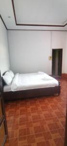 een groot bed in een kamer met een houten vloer bij 华泰酒店HUA TAI HOTEL in Vang Vieng