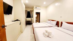 um quarto de hotel com duas camas e uma televisão em Chotika Hotel โรงแรมโชติกา ณ เชียงคาน em Chiang Khan