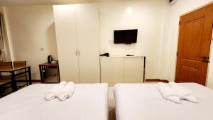 um quarto de hotel com duas camas com toalhas em Chotika Hotel โรงแรมโชติกา ณ เชียงคาน em Chiang Khan